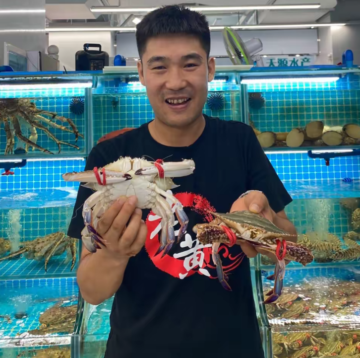 老黄海鲜店主人物照片，手持鲜活海鲜